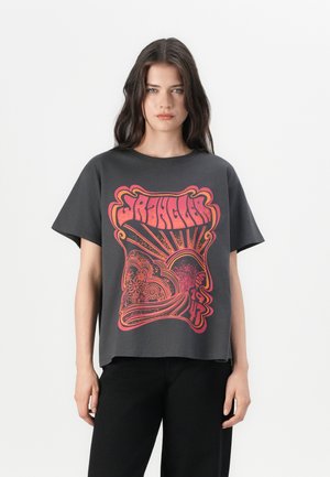 T-shirt gris avec un grand graphisme psychédélique rouge et orange présentant des motifs complexes. Manches courtes et coupe décontractée.