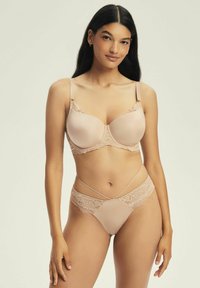Nagi biustonosz z koronkowym wykończeniem, z gładką, lekko puszystą miseczką i regulowanymi ramiączkami. Pasujące majtki z koronkowymi detalami i paskowym wzorem.