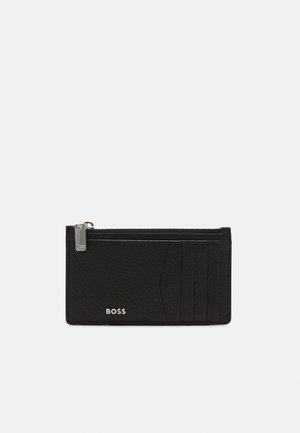 Black leather cardholder with textured finish, one zippered compartment, five slots for cards, and a subtle logo on the front.