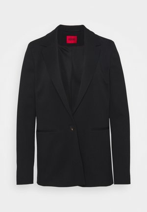 Blazer negro de un botón con solapas de muesca y dos bolsillos delanteros, con una etiqueta interior roja.
