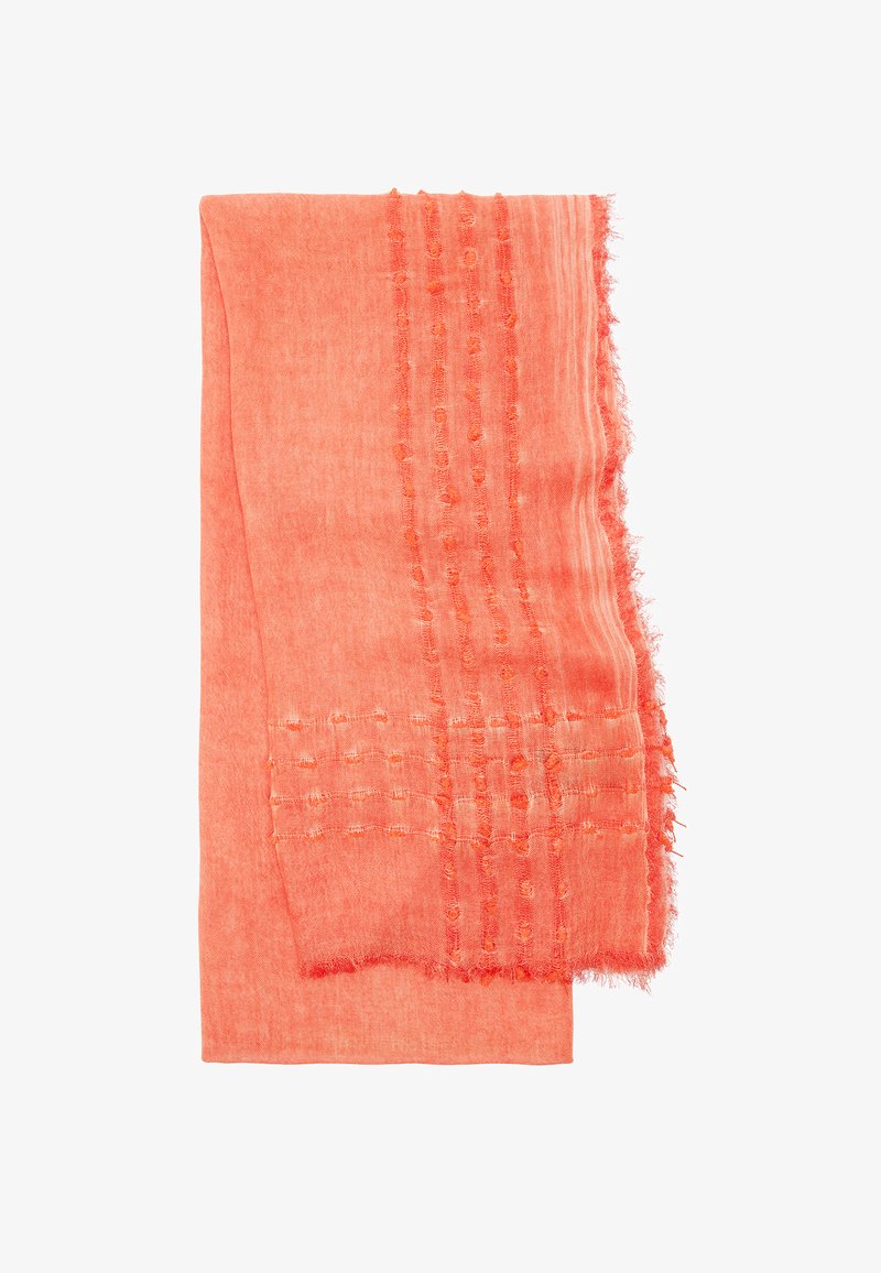 Korala szalik wykonany z miękkiego, teksturowanego materiału, z wzorami w formie wplecionych pasków oraz postrzępionymi brzegami, o wymiarach w przybliżeniu prostokątnych.