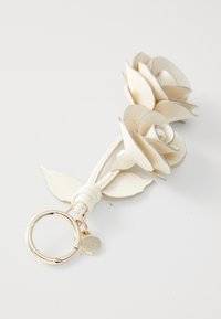 Keychain featuring three white leather rose flowers with gold hardware, textured petals, and green leather leaves attached to a circular ring.
