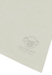 Hellbeiger Stoff mit glatter Textur, auf dem in der unteren Ecke ein Schaf-Logo mit dezenten Details abgebildet ist.
