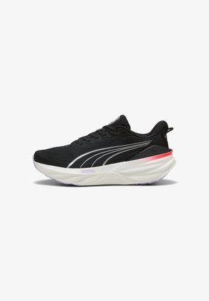 Chaussure de course Puma noire avec semelle blanche, bandes argentées sur le côté et accent rouge près du talon, vue de la face extérieure sur fond blanc.