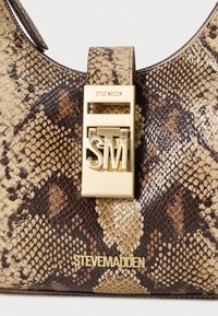 Borsa a tracolla con stampa di serpente marrone e beige, dalla finitura lucida. Presenta una chiusura in metallo dorato con il logo “SM” e il nome del brand impresso sul davanti.