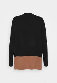 Pull en maille bicolore noir et marron, avec manches longues et texture côtelée, présentant un haut uni noir et un ourlet contrastant marron.