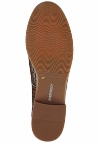 Parte superiore della scarpa intrecciata marrone con suola in gomma tan flessibile, caratterizzata da un motivo testurizzato e l'etichetta della taglia "37" sulla suola.