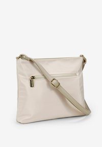 Borsa a tracolla beige realizzata in tessuto liscio, con una tasca con zip sul retro e una tracolla regolabile con dettagli in oro.