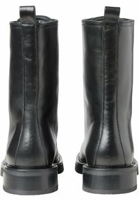Svarta läderankel stövlar med en slät textur, rak silhuett och rundade tår. Har en robust klack och en dragflik bak.
