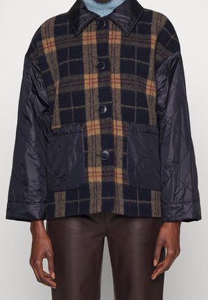 Veste en laine à carreaux et en nylon matelassé, arborant des couleurs bleu, marron et noir, avec deux poches avant et un fermeture à boutons.