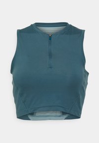 Ærmeløs atletisk croptop i teal, med kvartlynlås foran, tætsiddende design, glat tekstur og syninger langs kanten.