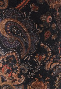 Tessuto nero con motivi paisley e floreali in tonalità ricche di arancio, marrone e viola; la finitura testurizzata aggiunge profondità al design.