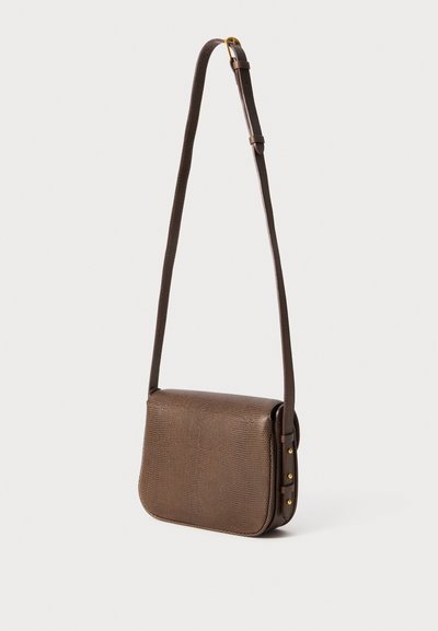 Sac en cuir texturé marron à bandoulière réglable avec des détails en boucle et rivets dorés, présenté sur un fond blanc.