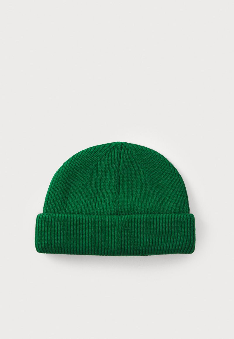 Groene gebreide beanie met geribbelde textuur en een omgeslagen rand. De stof lijkt zacht en rekbaar, geschikt voor koud weer.