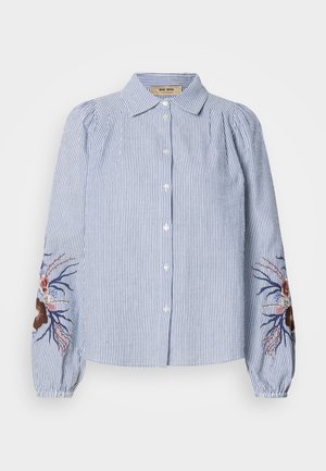 Ribaga sinine ja valge nööpidega särk pikkade varrukatega, mille varrukatel on tikandid lillede ja viinapuude kujutistega. Puuvillane kangas, vabalt langev lõige.