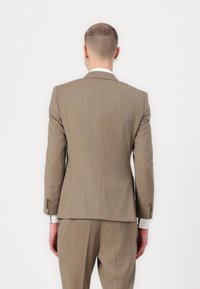 Giacca da uomo marrone a quadri con rever a punta, due bottoni e texture sottile. La vestibilità slim si abbina ai pantaloni coordinati. Vista posteriore mostrata.