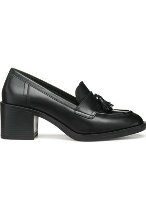 Zwarte leren damesloafer met tassel-detail, ronde neus en blokhak, zijaanzicht op witte achtergrond.