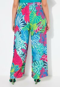 Losse, kleurrijke broeken met een levendige tropische bloemenprint in tinten groen, roze en blauw, met een wijduitlopende pasvorm en een elastische taille.