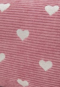 Tissu côtelé rose avec des motifs de cœurs blancs. La texture est nervurée, ajoutant de la profondeur au design.