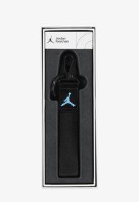Black Jordan keychain featuring a sturdy fabric strap, a black clip, and a light blue logo. Packaged in a sleek white box with minimal design.