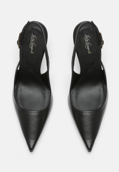 Par sorte læder flade sko med spids tå og slingback-remme med justerbare side-spænder samt mærkede indlægssåler på hvid baggrund.