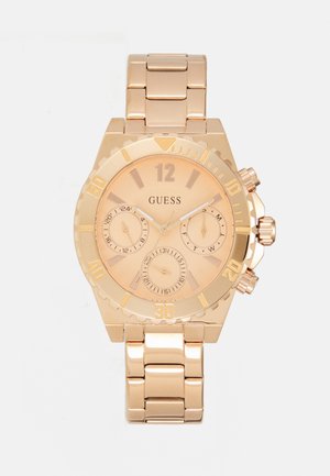 La montre en acier inoxydable rose gold dispose d'un cadran rond, de trois sous-cadrans et de grands index horaires. Son bracelet de style chaîne a une finition polie.