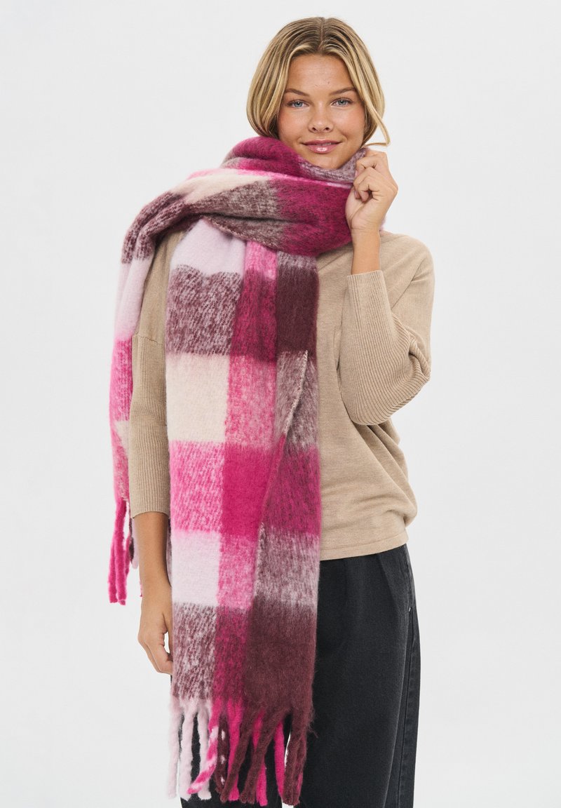 Stor ternet tørklæde med nuancer af pink, burgundy og creme. Lavet af et blødt materiale med frynser i kanten og en struktureret overflade.