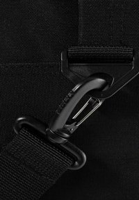 Schwarzer Stoffgurt mit einem Plastikclip und einem metallischen Karabinerhaken. Strukturierten Hintergrund und glattes Hardware-Detail sichtbar.