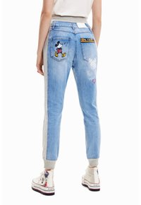 Světle modré denimové joggers s šedými bočními panely, na zadní kapse s vyšitým Mickey Mousem a textem "Následuj své srdce".