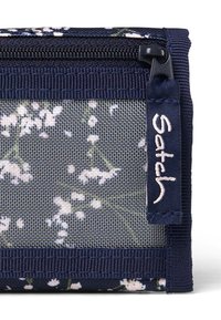 Floral print wallet in navy and white, featuring mesh texture, zip closure, and a navy fabric tag with white stitching reading "Satch."