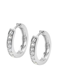 Srebrne kolczyki w kształcie obręczy z rzędem przezroczystych kryształków po jednej stronie, gładka powierzchnia i wypolerowane wykończenie. Okrągły kształt.