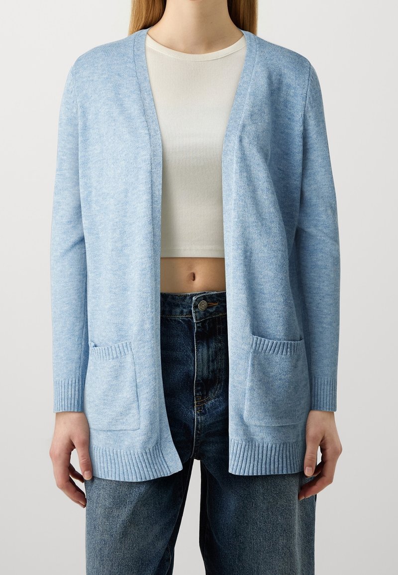 Cardigan bleu clair avec une coupe décontractée, ouverture frontale, poignets côtelés et deux poches avant. Confectionné dans un matériau tricoté doux.