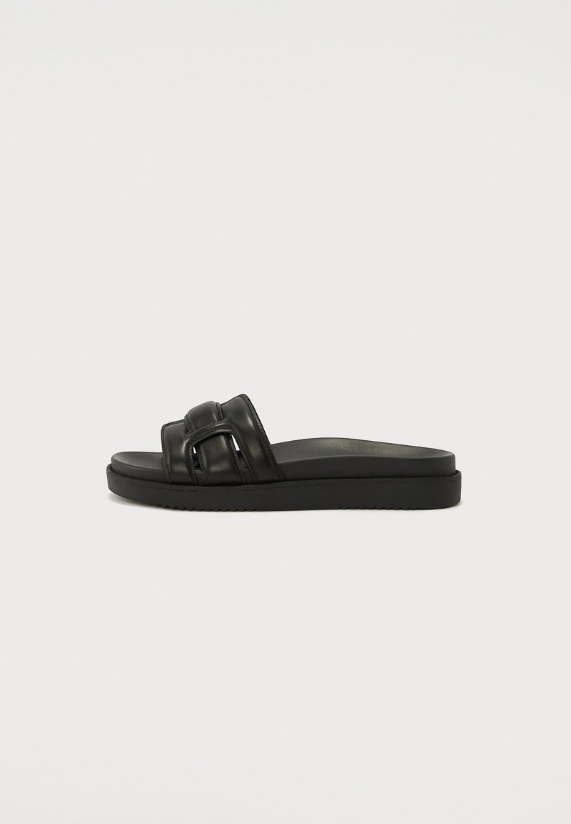 Black slide sandal with two padded straps and a flat cushioned sole, shown from the side on a plain light background.