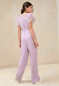 Lila Jumpsuit mit transparenten kurzen Ärmeln, weitem Bein-Design und einem Bindegürtel in der Taille. Glatte Textur mit einem Reißverschluss auf der Rückseite.