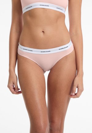 Svetlo roza bikiniji z nizko pasom, ki imajo belo elastično pasnico s črnim tiskom "GUESS JEANS". Gladka tekstura, prilegnjena zasnova.