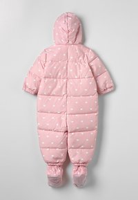 Roze gewatteerde baby-sneeuwpak met een wit hartpatroon, elastische manchetten en aangehechte voetjes met gripzolen, weergegeven vanuit de achterkant.