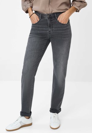 Graue Denim-Jeans mit geradem Schnitt, Fünf-Taschen-Design, dezentem Verblassen und umgeschlagenen Bündchen, kombiniert mit weißen Sneakern.
