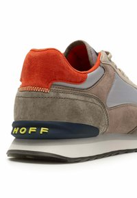 Sneaker mit einer Kombination aus grauem Wildleder und orangefarbenen Akzenten, einer glatten grauen Fläche, einer gepolsterten Sohle und einem grünen "Hoff"-Label an der Ferse.
