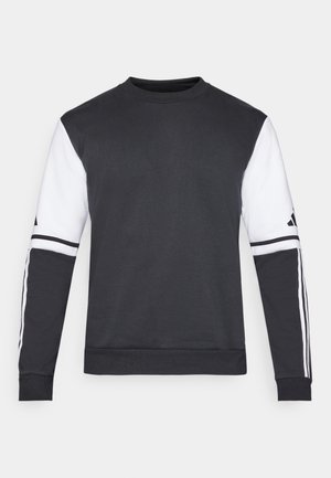 Melnā un baltā krāsā crewneck džemperis ar garām piedurknēm, kas ir ar kontrastējošu krāsu piedurknēm un trim baltām svītrām gar roku daļu.