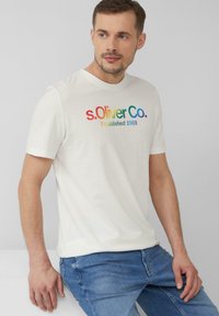 Witte katoenen T-shirt met een kleurrijk logo "s.Oliver Co." en de tekst "Established 1969". Korte mouwen, ronde hals, relaxed fit.