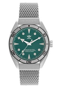 Montre en acier inoxydable avec un cadran teal, des index argentés et un bracelet en maille. Elle dispose d'une lunette rotative et d'un logo adidas sur le cadran.
