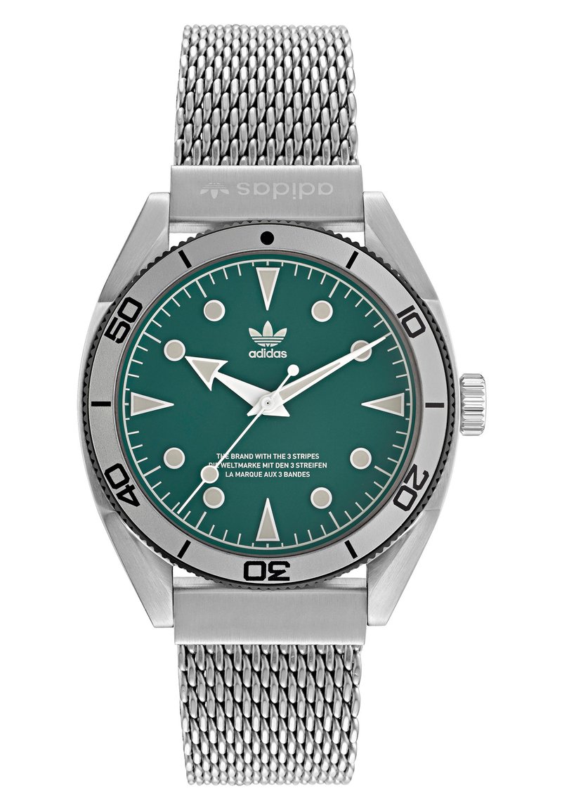 Montre en acier inoxydable avec un cadran teal, des index argentés et un bracelet en maille. Elle dispose d'une lunette rotative et d'un logo adidas sur le cadran.