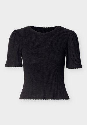 Fekete bordázott felső rövid, pöttyös ujjakkal és hullámos kivágással. Testhez simuló fazon, texturált anyagból, rövidített szegéllyel.