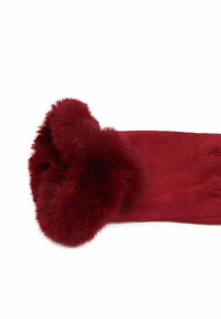 Guanto in suede rosso con folto bordo di pelliccia morbida intorno al polso, poggiato su uno sfondo bianco.