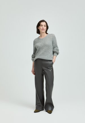 Light gray knit sweater with rolled sleeves, paired with high-waisted dark gray faux leather wide-leg pants and green pointed-toe shoes.