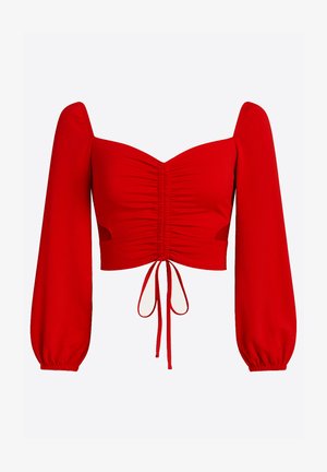 Top corto rojo con mangas largas abullonadas, detalle fruncido en el frente y cierre con lazo. Hecho de tela suave, con recortes en los costados.