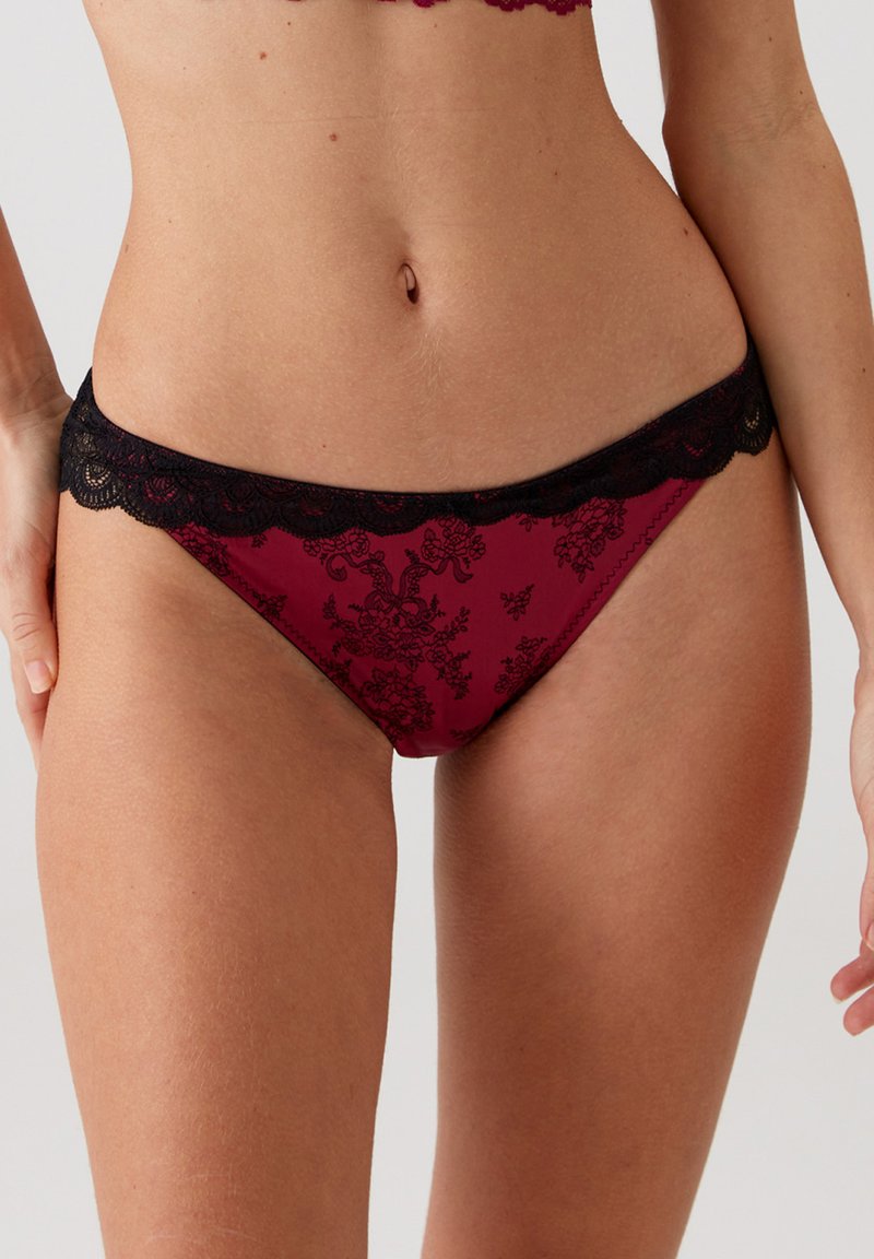 Bordeaux lace-trimmed slips met een bloemmotief en een zwarte elastische tailleband. Zachte stof met een gladde textuur en decoratieve accenten.