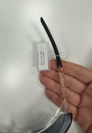 Montura de gafas negra con una patilla clara y transparente. La patilla presenta ranuras y una etiqueta que indica "NO EN VENTA." Acabado liso y brillante.