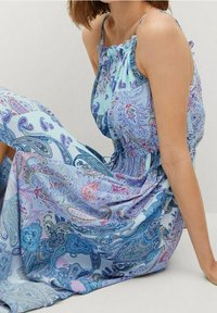 Maxikleid aus leichtem blauen Stoff mit Paisleymuster in Blau-, Rosa- und Lilatönen. Verstellbare Träger und geraffte Taillenpartie.