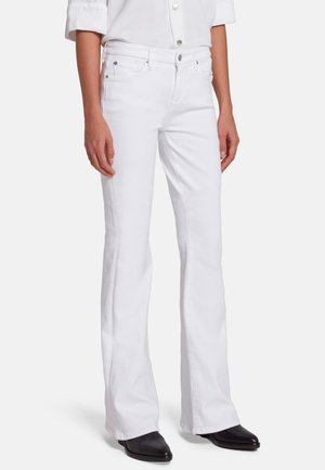 Hvide flare jeans med et klassisk femlomme-design og knaplukning. Lavet af denim med en glat tekstur. Båret med sorte spidse støvler.